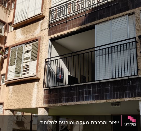 מעקה ברזל שחור עם מוטות אנכיים במרפסת דירה בבניין מגורים